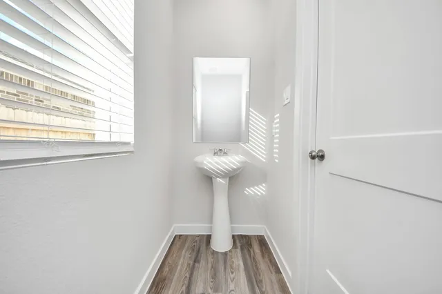 a view of a hallway with wooden floor and a chandelier