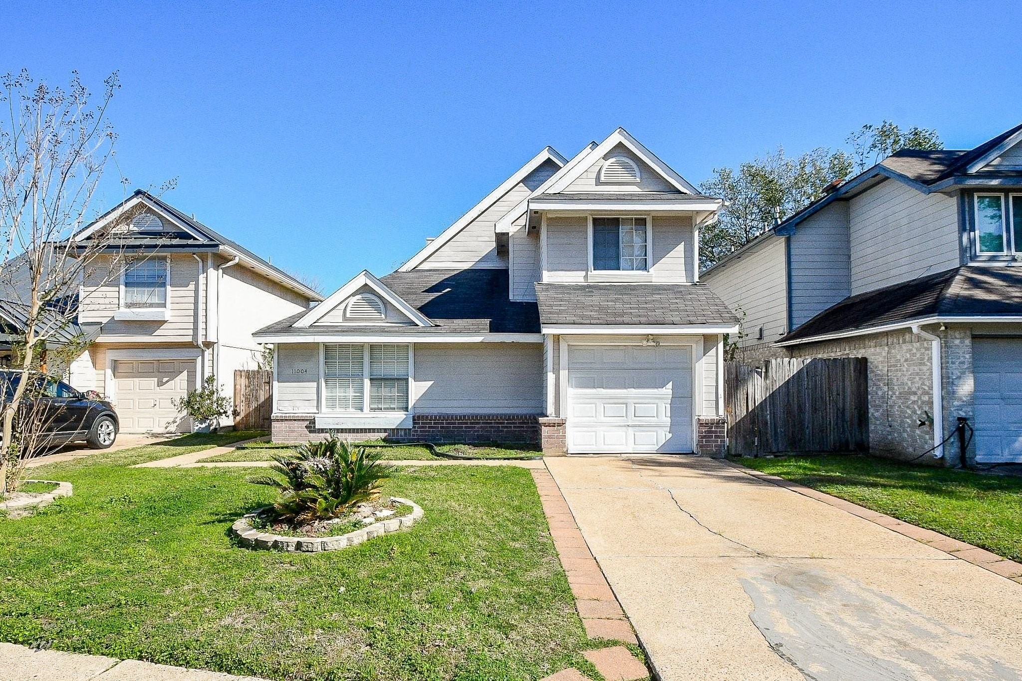 a front view of a house with a yard and trees