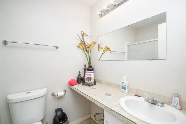 a bathroom with a sink vanity mirror and toilet