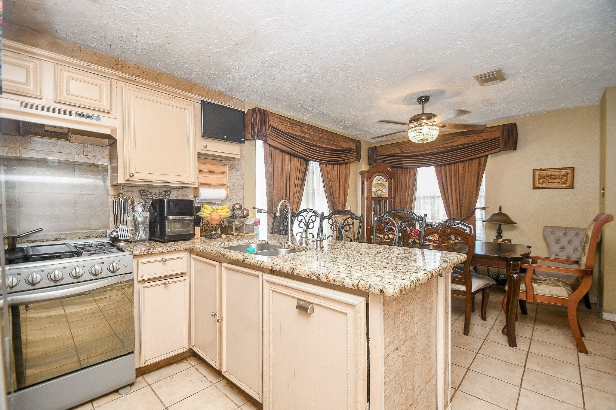 11004 Rustling Winds Drive Houston, TX 77064 - Photo 7 of 20 a kitchen with a stove a sink a dining table and chairs