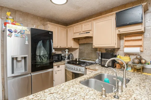 a kitchen with a refrigerator stove and sink
