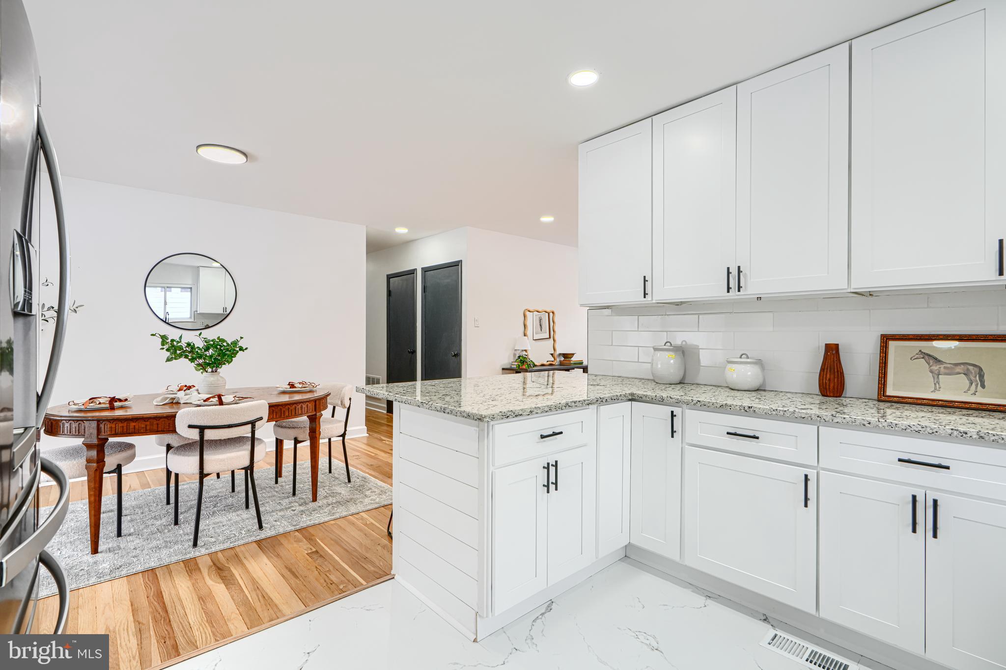 6112 Chesworth Road Baltimore, MD 21228 - Photo 22 of 47 a view of kitchen with white cabinets stainless steel appliances and dining table