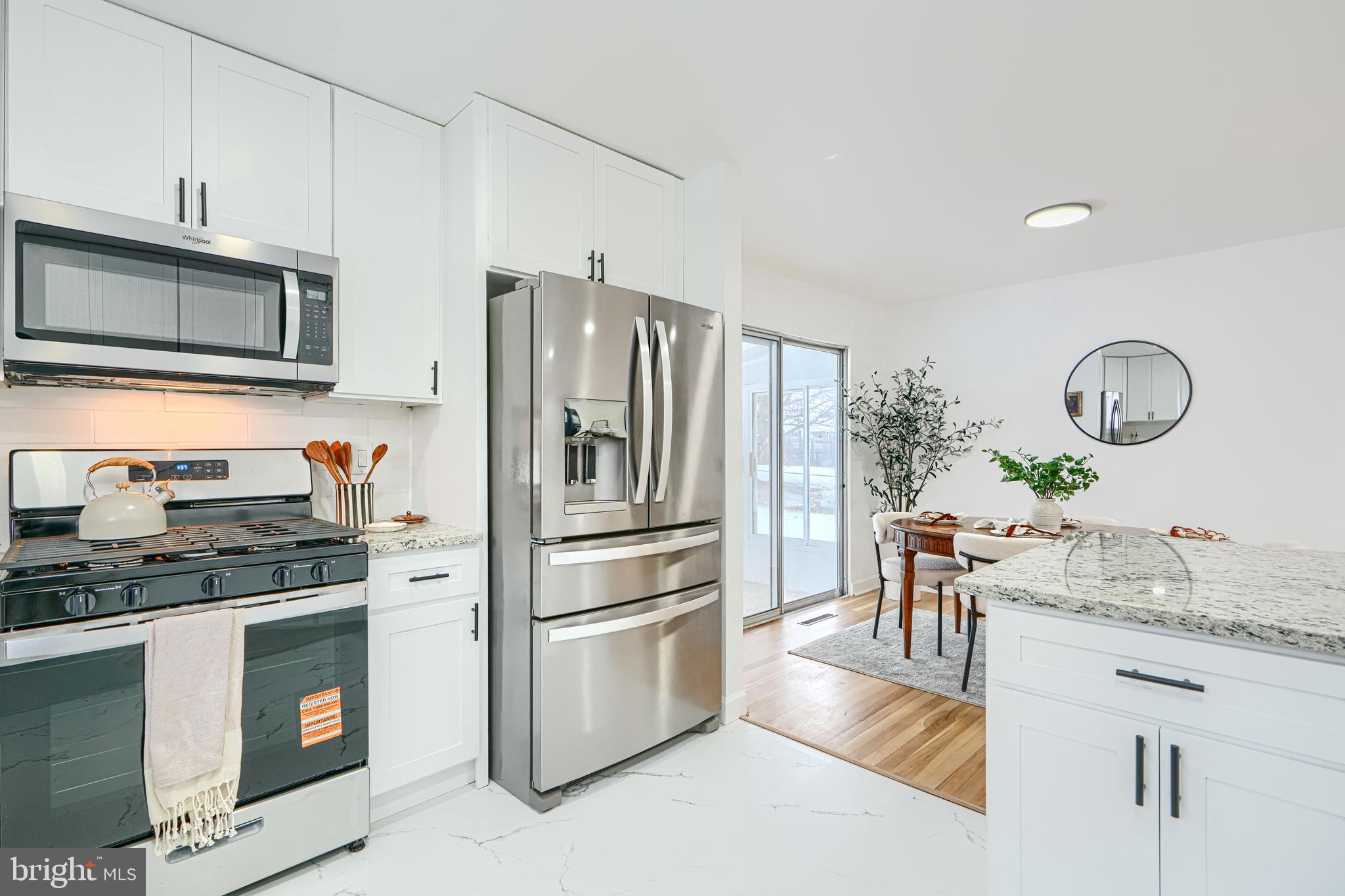 6112 Chesworth Road Baltimore, MD 21228 - Photo 23 of 47 a kitchen with granite countertop a refrigerator stove top oven and sink