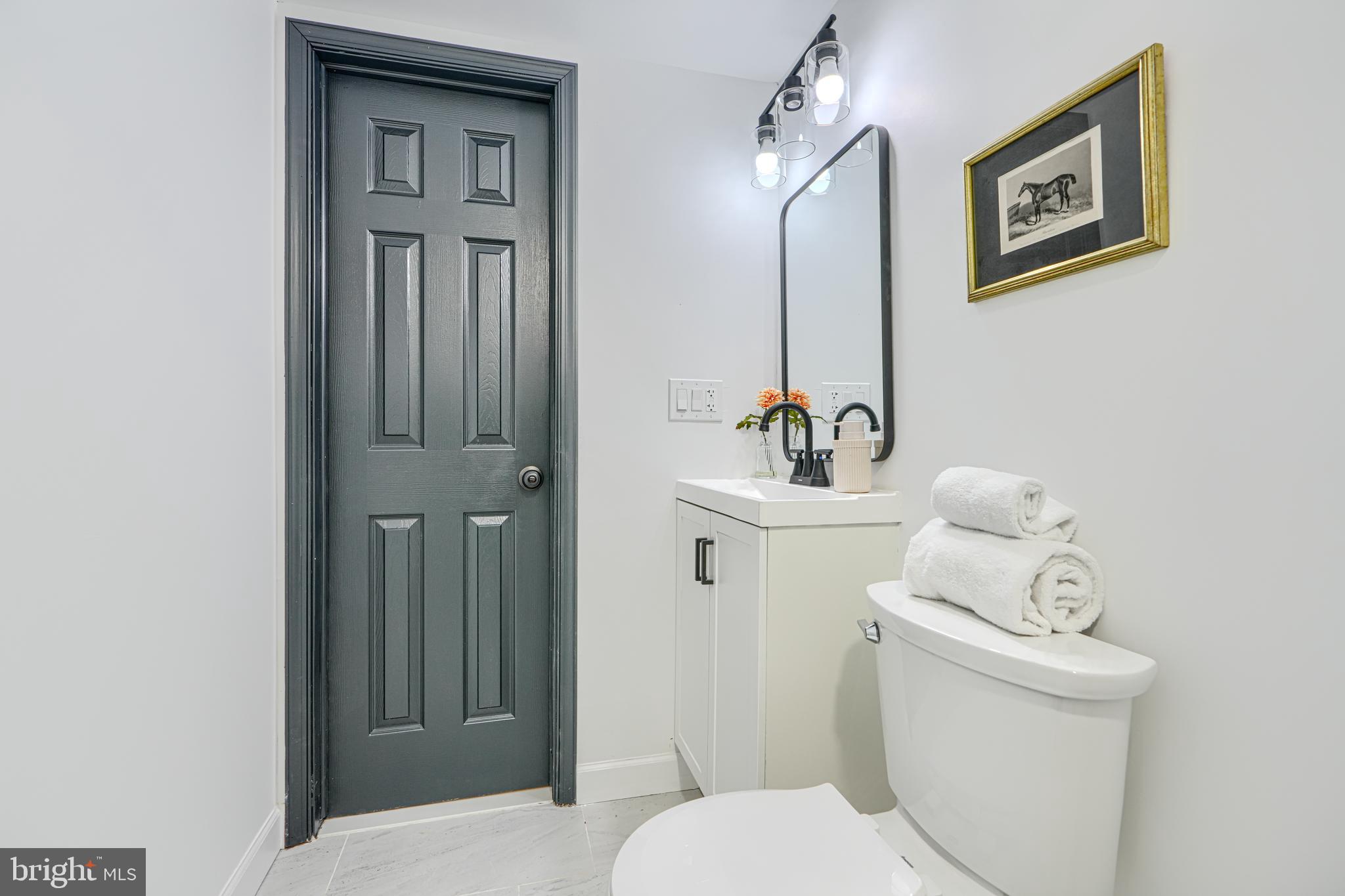 6112 Chesworth Road Baltimore, MD 21228 - Photo 44 of 47 a bathroom with a toilet sink and mirror