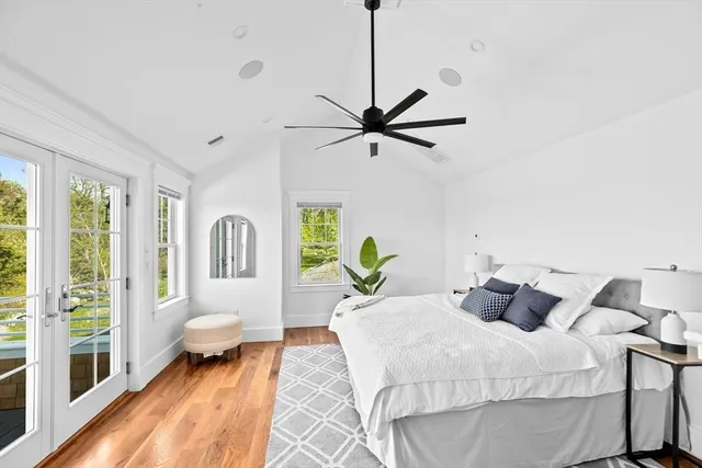 a bedroom with a balcony a bed and a large window