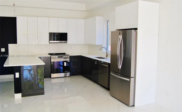 a kitchen with stainless steel appliances a refrigerator stove and microwave