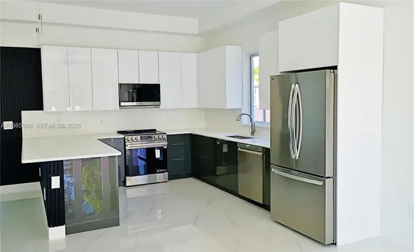 a kitchen with stainless steel appliances a refrigerator stove and microwave