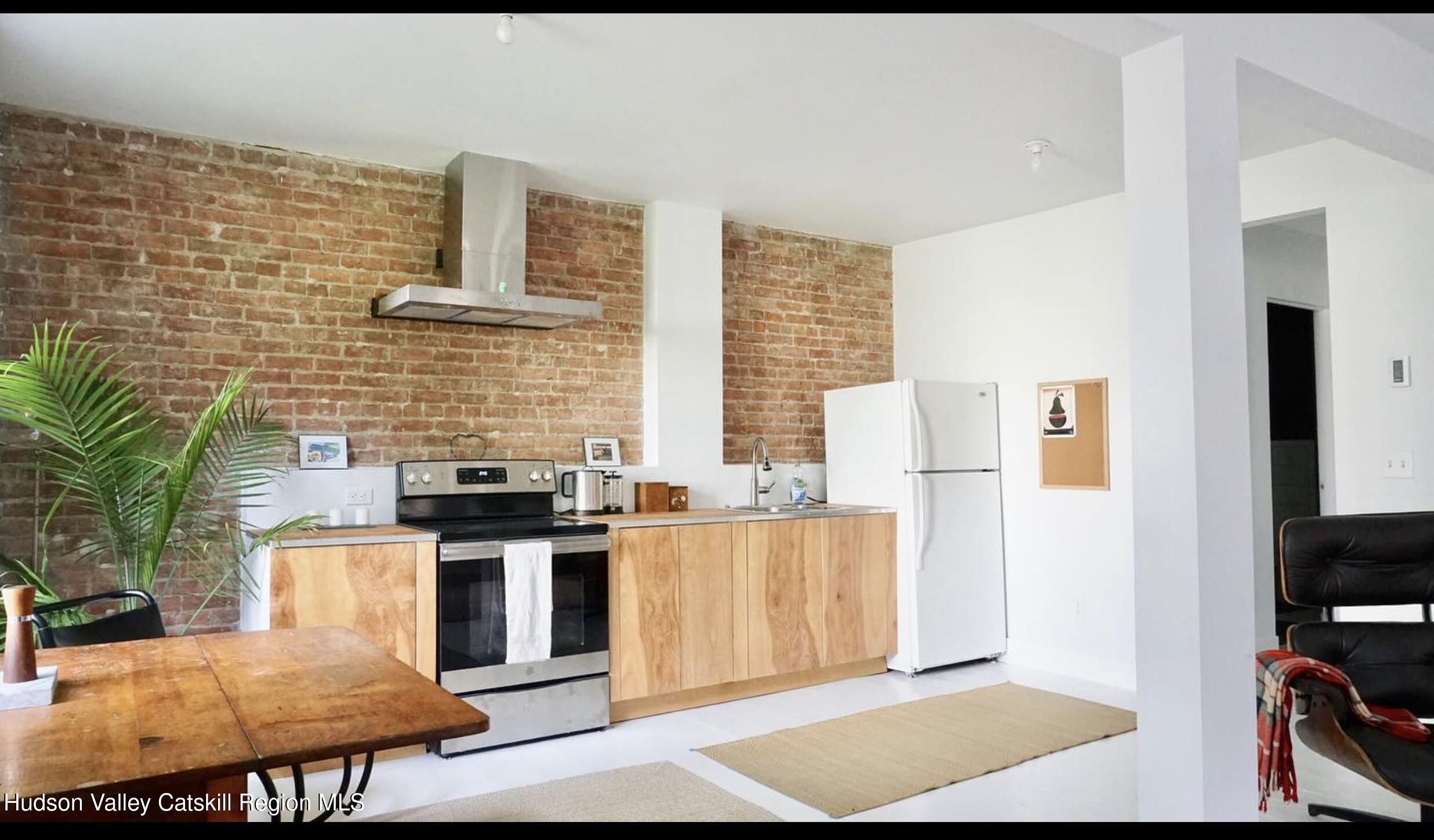524 State Street Hudson, NY 12534 - Photo 2 of 8 a kitchen with stainless steel appliances kitchen island granite countertop a stove and a refrigerator