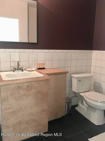 a bathroom with a sink a toilet and a mirror