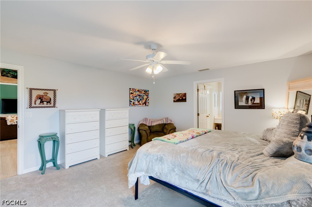 3801 28th Street Southwest Lehigh Acres, FL 33976 - Photo 18 of 37 a bedroom with a bed and a chandelier