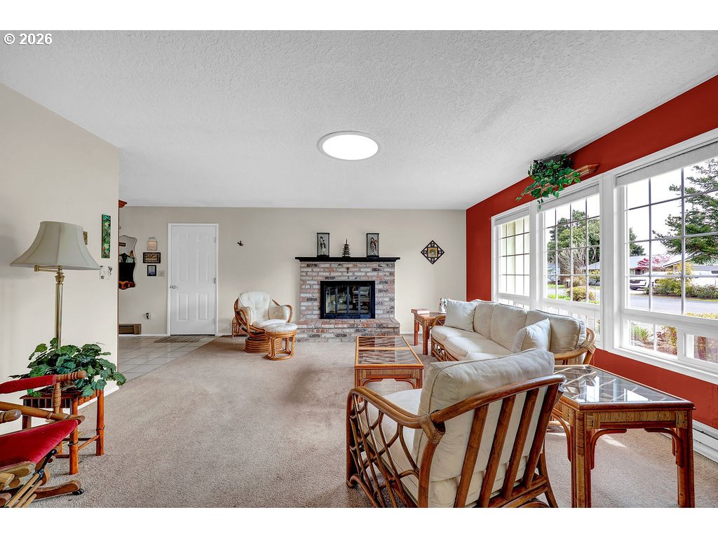 1415 20th Street Florence, OR 97439 - Photo 6 of 40 a living room with furniture a fireplace and a large window