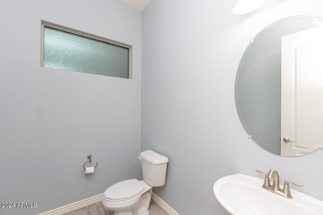Undisclosed Address Gilbert, AZ 85298 - Photo 12 of 36 a bathroom with a toilet sink and mirror