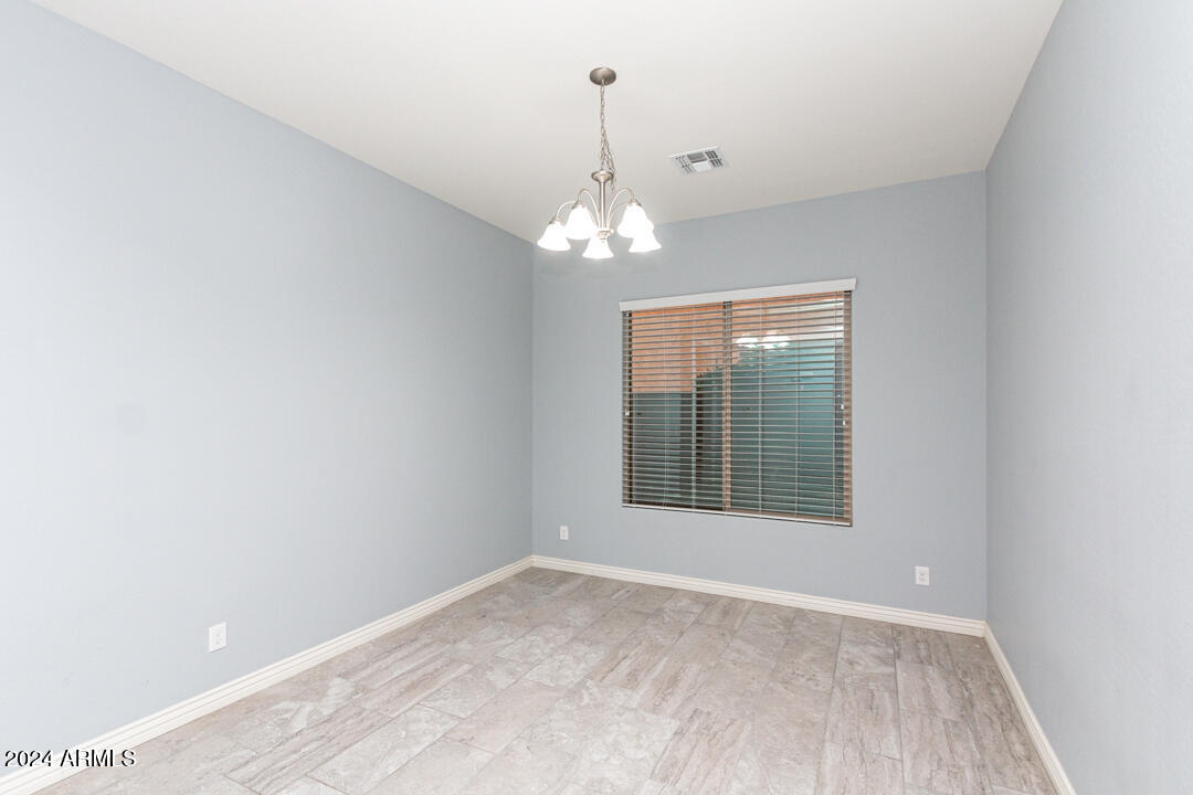 Undisclosed Address Gilbert, AZ 85298 - Photo 13 of 36 an empty room with chandelier fan and windows
