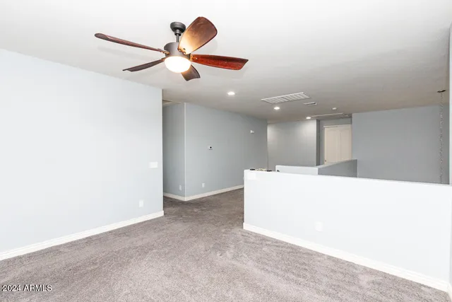 a view of a livingroom with a ceiling fan and wooden floor