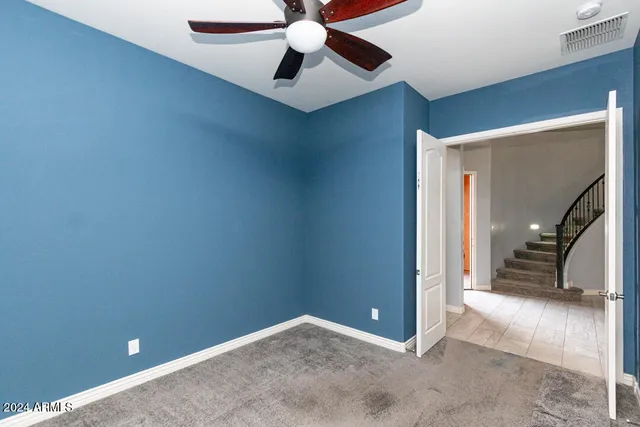 an empty room with closet and a chandelier fan