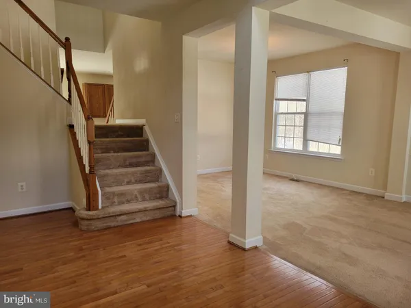 a view of a livingroom with wooden floor and stairs