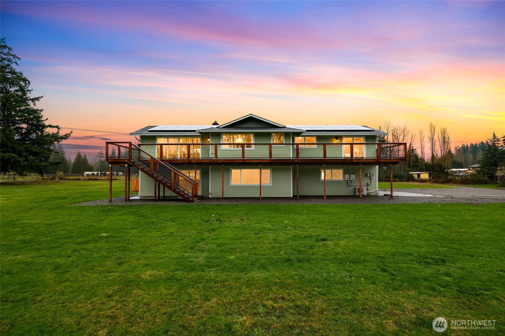 a view of a big house with a big yard and large trees