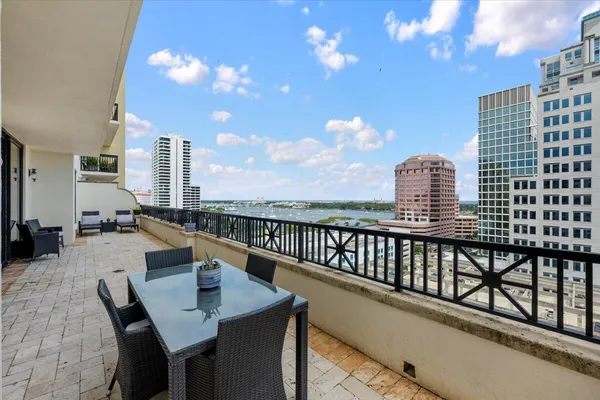 a view of a balcony with dining table and chairs