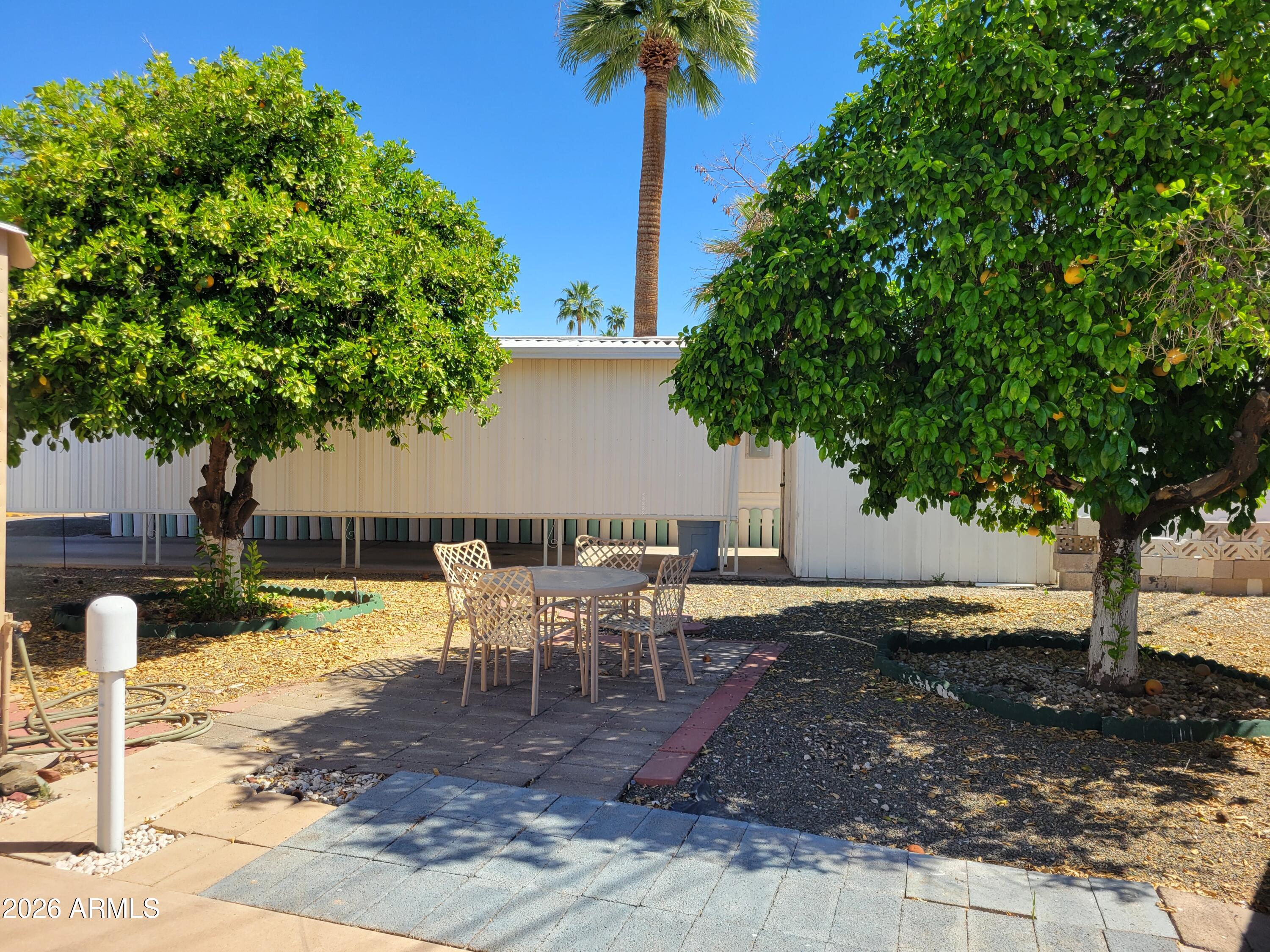 2460 East Main Street, Unit S03 Mesa, AZ 85213 - Photo 16 of 21 a view of a backyard with table and chairs couches under an umbrella