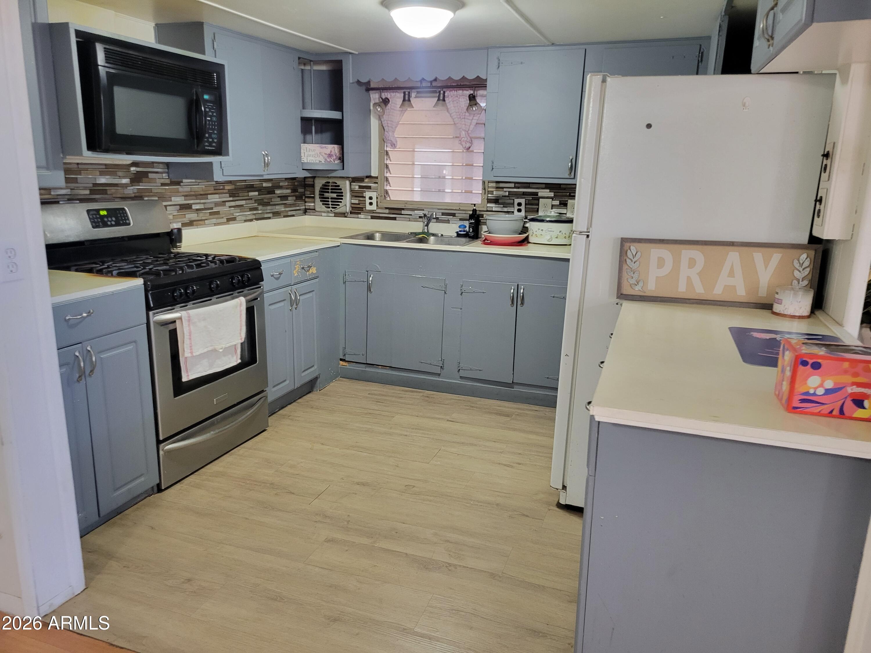 2460 East Main Street, Unit S03 Mesa, AZ 85213 - Photo 2 of 21 a kitchen with stainless steel appliances a stove refrigerator sink and microwave