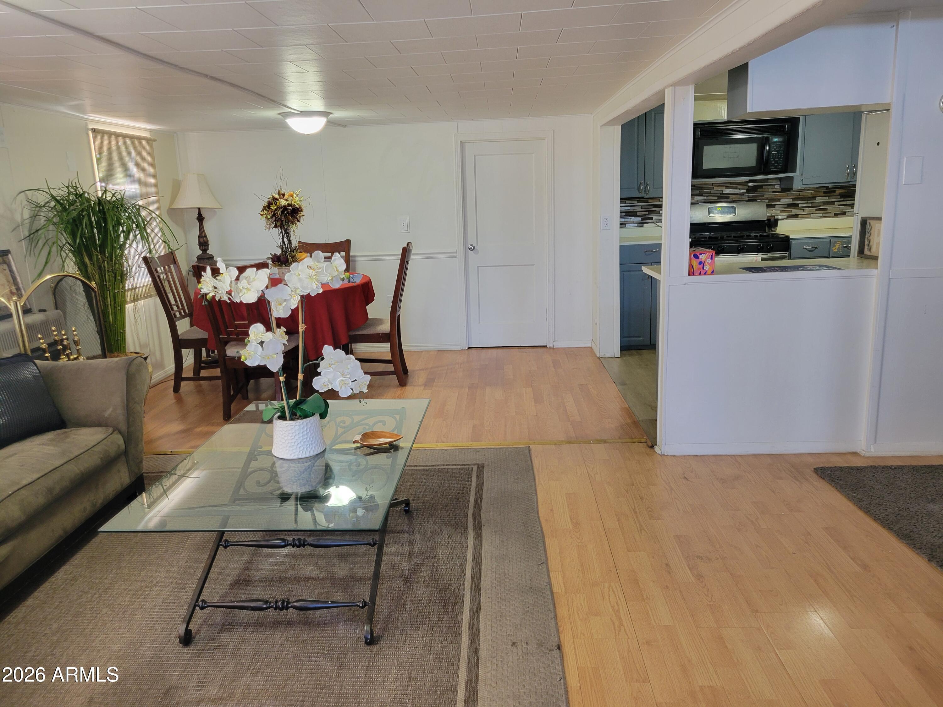 2460 East Main Street, Unit S03 Mesa, AZ 85213 - Photo 4 of 21 a living room with furniture a flat screen tv and kitchen view