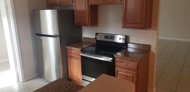 a kitchen with stainless steel appliances granite countertop a refrigerator and a stove