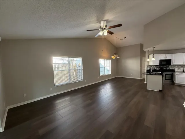 a kitchen with refrigerator a stove and white cabinets