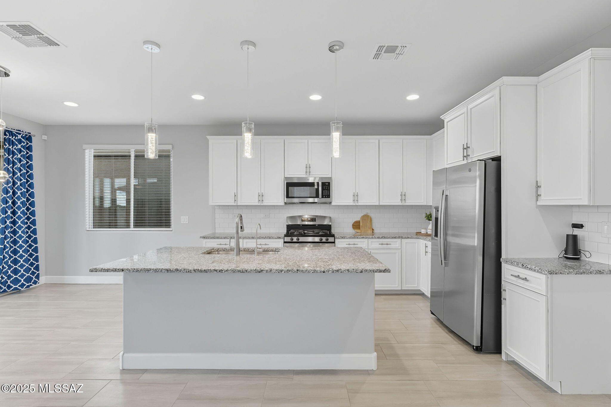 12100 East Ryscott Circle Vail, AZ 85641 - Photo 15 of 53 a large kitchen with stainless steel appliances granite countertop a stove a sink a refrigerator and white cabinets with wooden floor