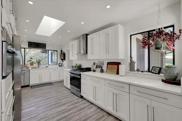 a kitchen with stainless steel appliances a refrigerator and a stove top oven