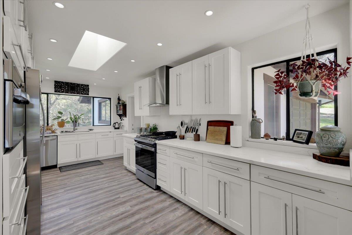 17513 Derby Way Penn Valley, CA 95946 - Photo 13 of 78 a kitchen with white cabinets and stainless steel appliances