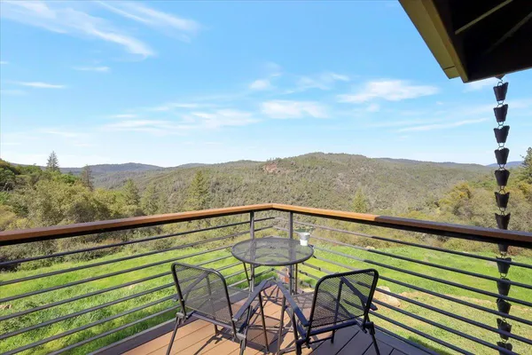 a view of a chair and table in backyard of the house