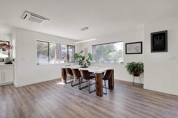 a living room with stainless steel appliances furniture a fireplace and wooden floor