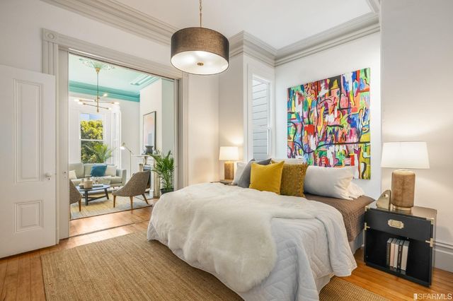 a bedroom with a bed and a painting on the wall