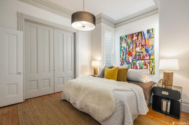 a view of a hallway with wooden floor and a bathroom