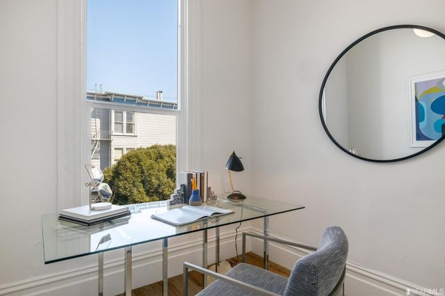 a view of a cafe with a couple of people sitting in front of retail shops