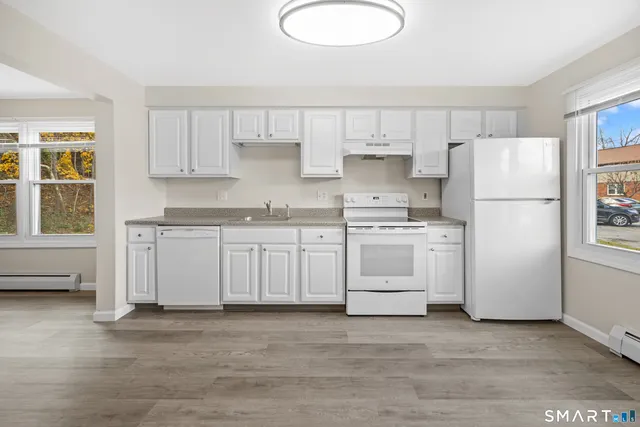 a kitchen with white cabinets and white appliances