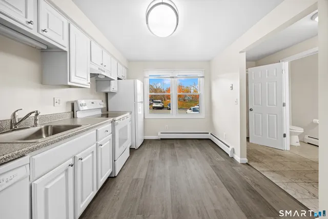 a kitchen with granite countertop a sink stove and cabinets