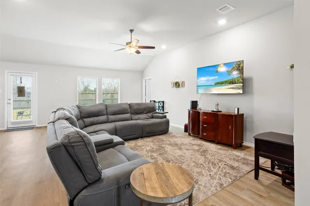 a living room with furniture and a wooden floor