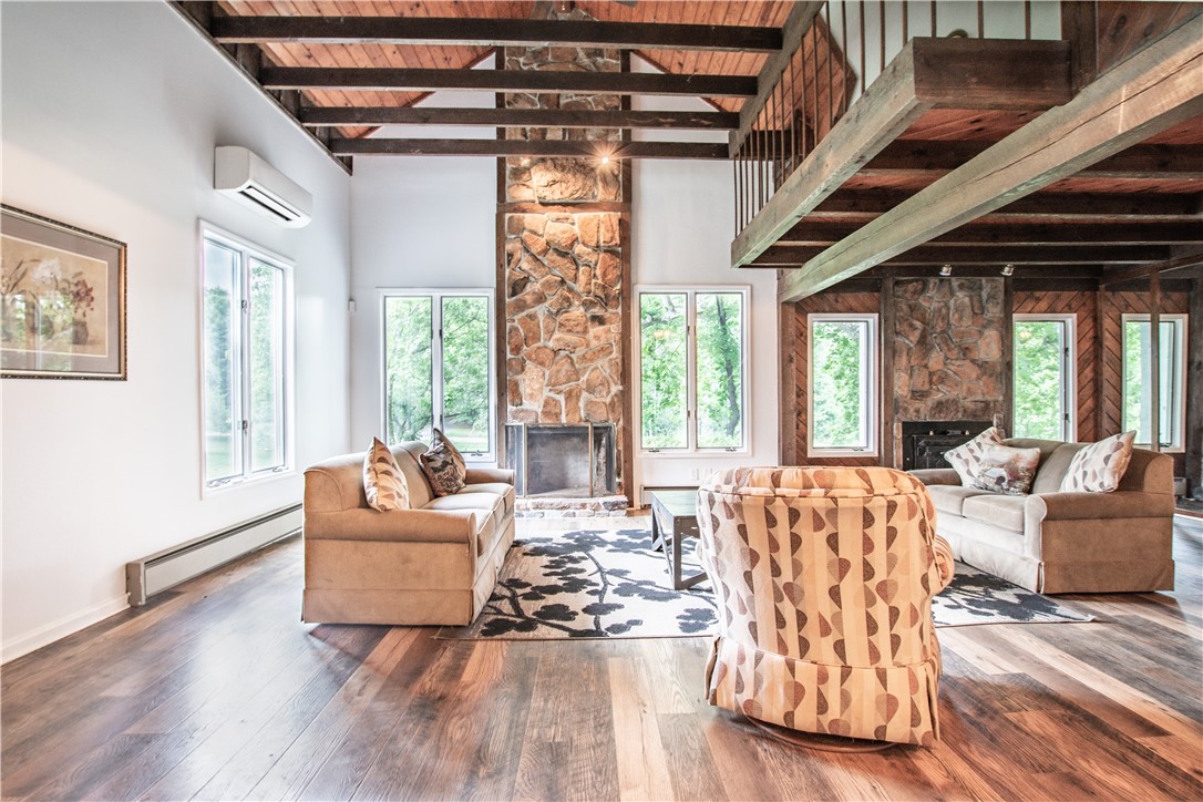 200 Chenault Road Townville, SC 29689 - Photo 7 of 47 A spacious living room with a rustic stone fireplace and exposed wood beams.
