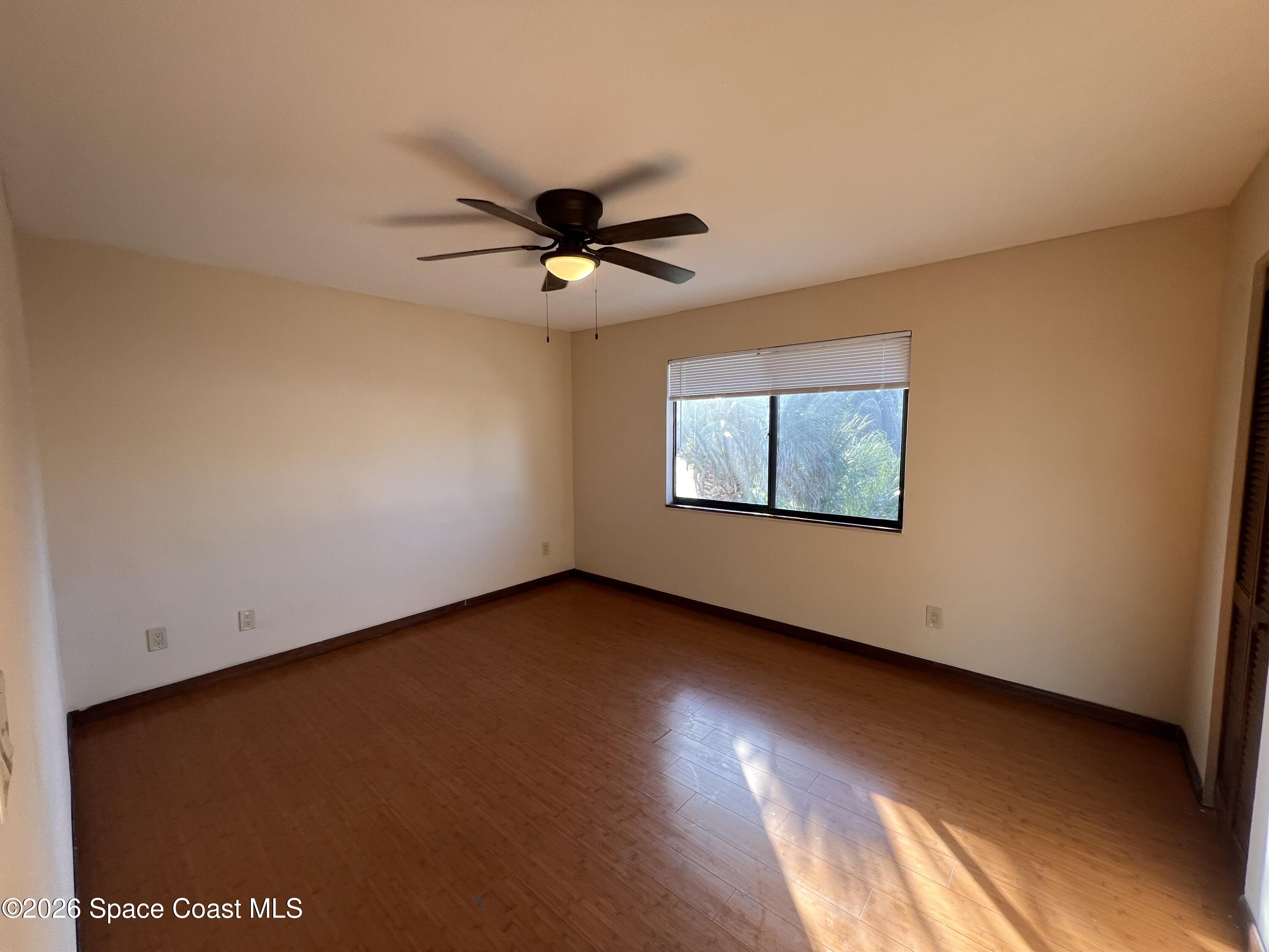 4611 Tree Ridge Lane Northeast Palm Bay, FL 32905 - Photo 12 of 19 an empty room with wooden floor and windows
