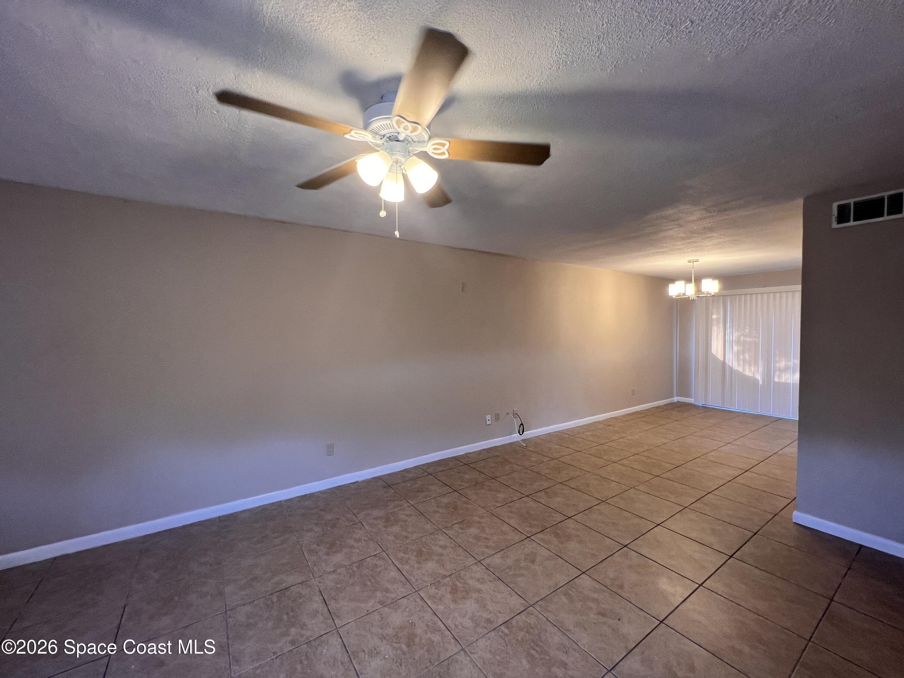 4611 Tree Ridge Lane Northeast Palm Bay, FL 32905 - Photo 5 of 19 an empty room with windows and fan