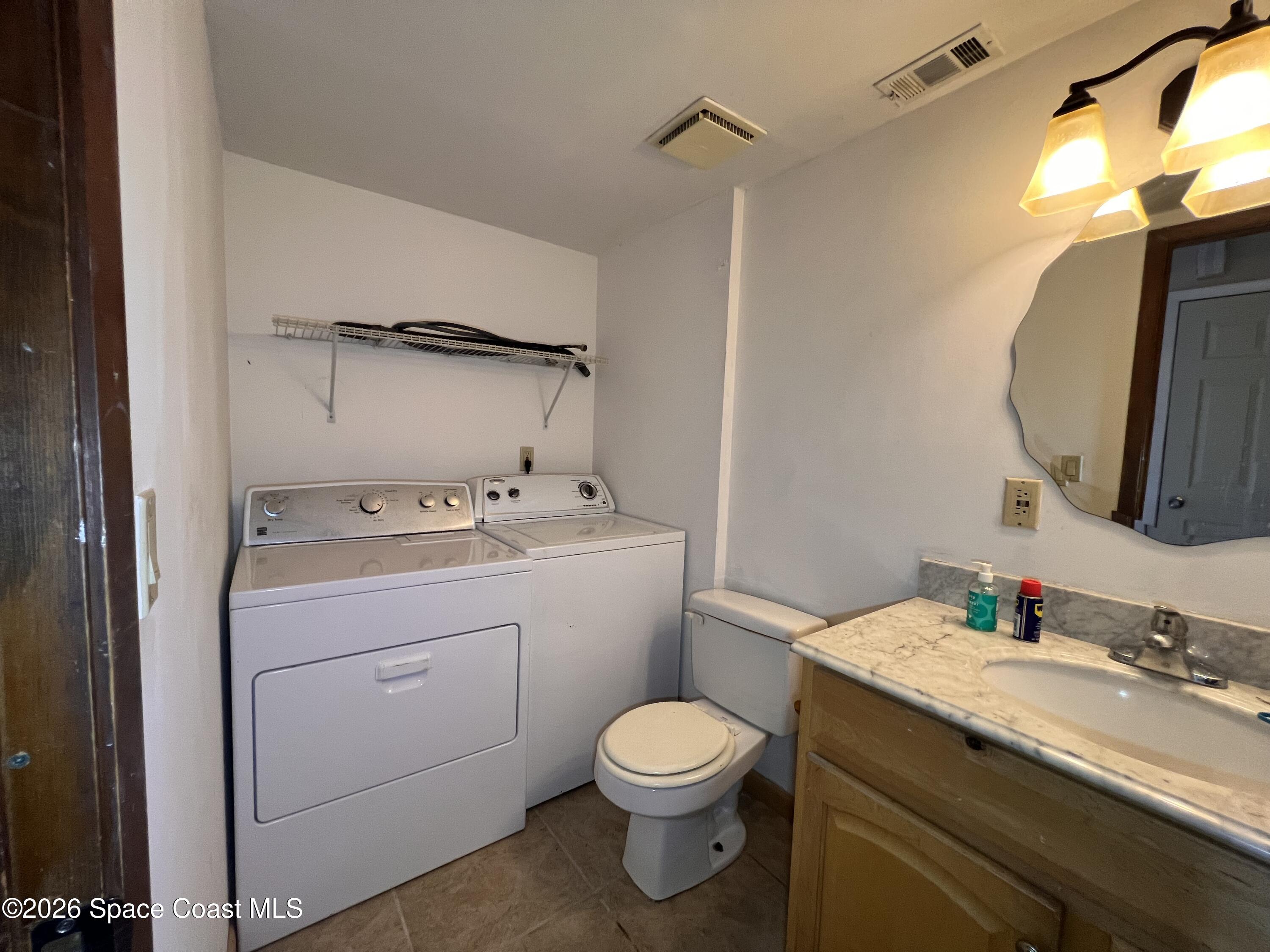 4611 Tree Ridge Lane Northeast Palm Bay, FL 32905 - Photo 6 of 19 a bathroom with a sink toilet and mirror