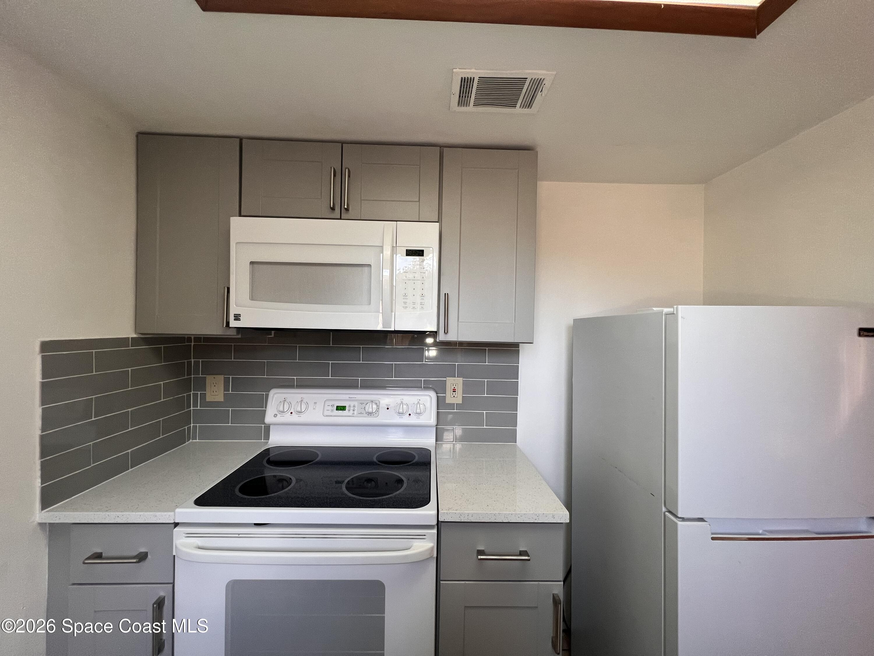 4611 Tree Ridge Lane Northeast Palm Bay, FL 32905 - Photo 9 of 19 a kitchen with a stove and a microwave