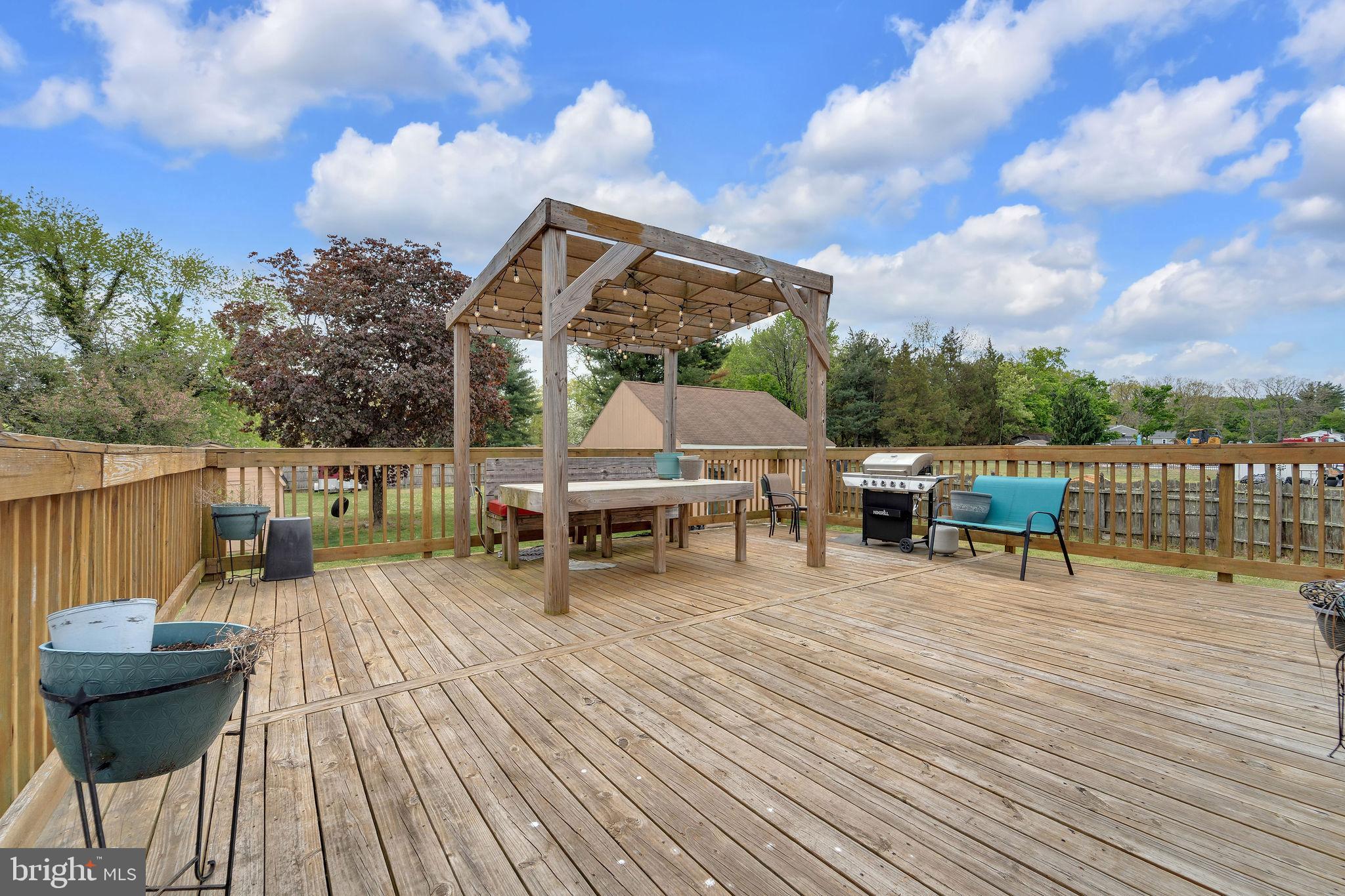 60 Waterford-Blue Anchor Road Hammonton, NJ 08037 - Photo 7 of 30 a view of a roof deck with table and chairs a barbeque with wooden floor and fence