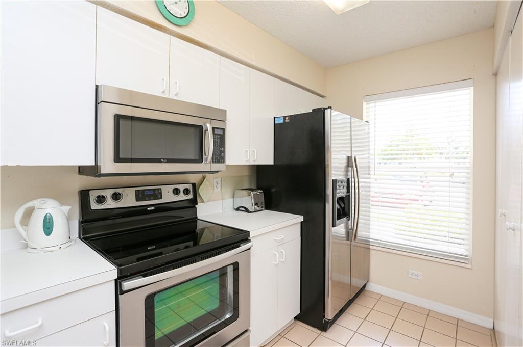 287 Quail Forest Boulevard, Unit 117 Naples, FL 34105 - Photo 1 of 29 a kitchen with a stove microwave and refrigerator