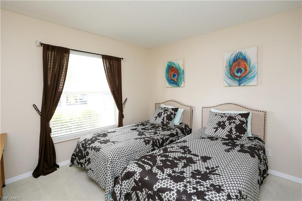 287 Quail Forest Boulevard, Unit 117 Naples, FL 34105 - Photo 13 of 29 a bed sitting in a bedroom next to a window