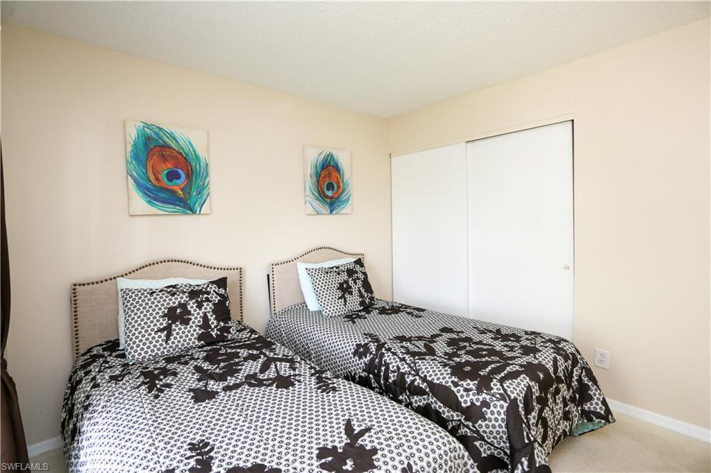 287 Quail Forest Boulevard, Unit 117 Naples, FL 34105 - Photo 14 of 29 a bedroom with a bed and a window
