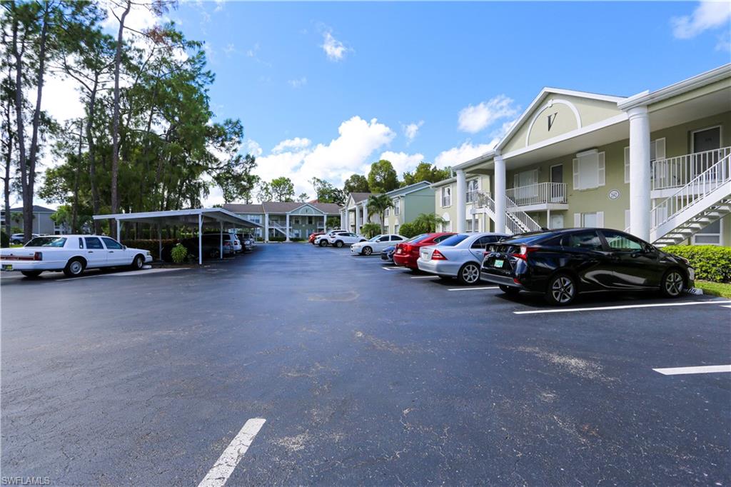 287 Quail Forest Boulevard, Unit 117 Naples, FL 34105 - Photo 19 of 29 a view of a cars park in front of a building