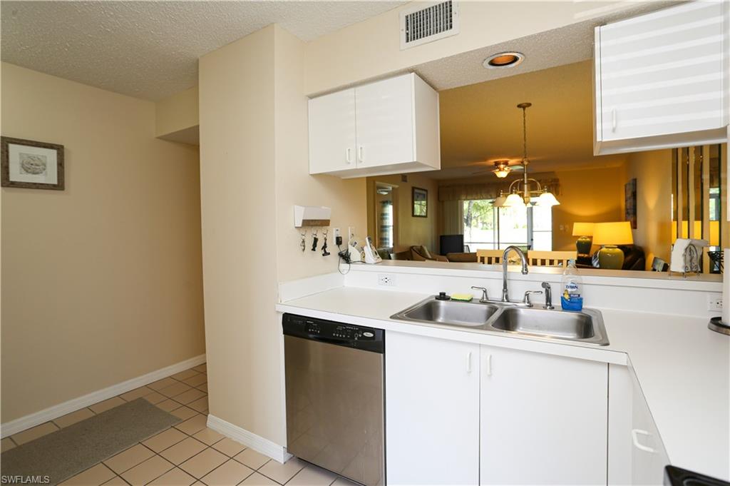 287 Quail Forest Boulevard, Unit 117 Naples, FL 34105 - Photo 2 of 29 a kitchen with a sink cabinets and a window