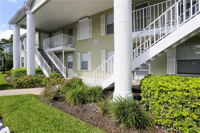 a front view of a multi story building with yard